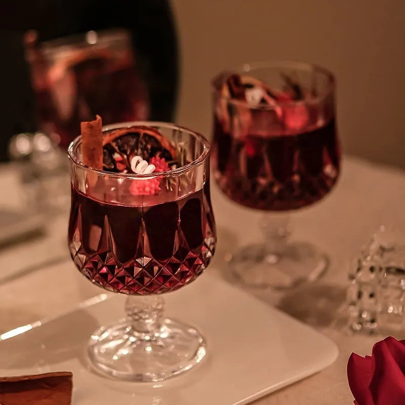 Clear glass wine goblet containing a scented candle with French mulled wine style