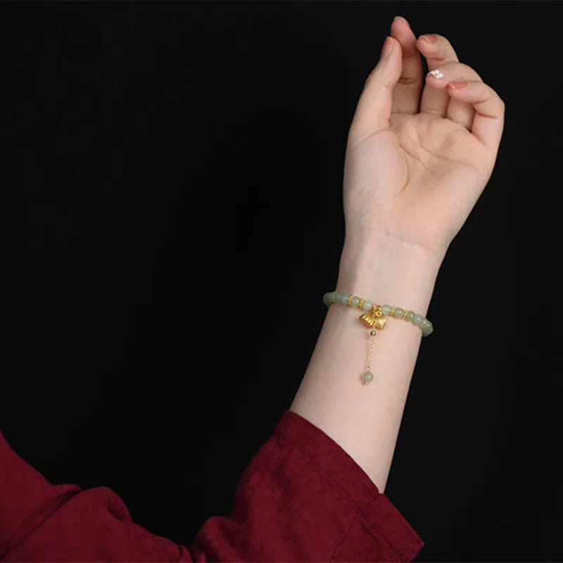 Two Shihuan natural Hetian jade bracelet with 6mm beads, fu charm, and lotus motif on a wrist.