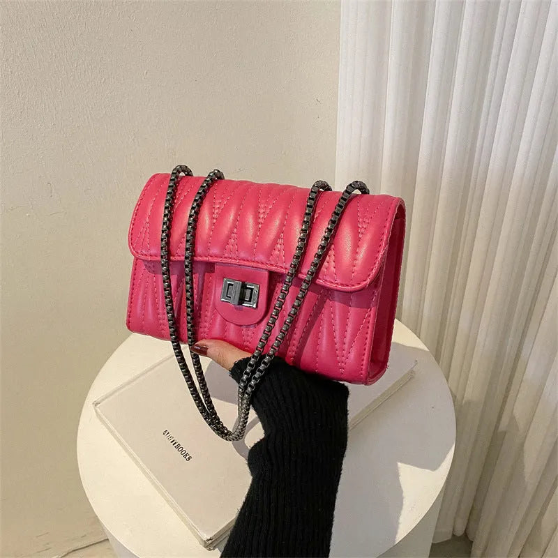 Small textured diamond pattern PU crossbody bag in multiple colours showing front slit pocket.