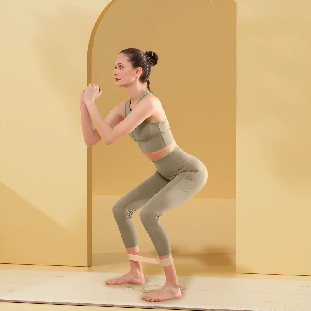 Four elastic resistance bands in green, beige, orange, and pink colours representing 30, 20, 15, and 10 lbs resistance levels