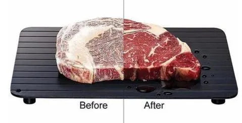 Black aluminium quick defrosting tray for thawing meat and frozen food on a kitchen counter.