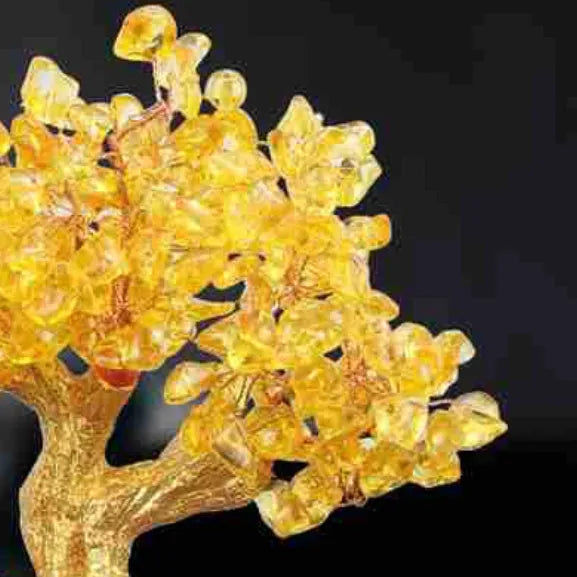 Citrine coloured resin small water turtle money tree Feng Shui ornament on a surface.
