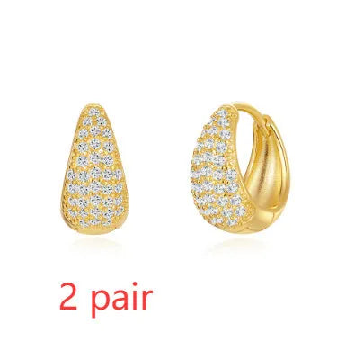Geometric brass earclip earrings with a gold electroplated finish and round design details.