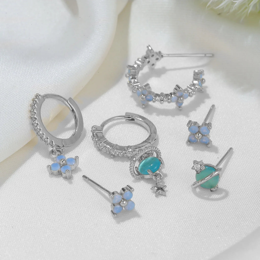 Gold and silver Japanese Korean style stud earrings with blue flower nail shape and zircon mosaic detail.