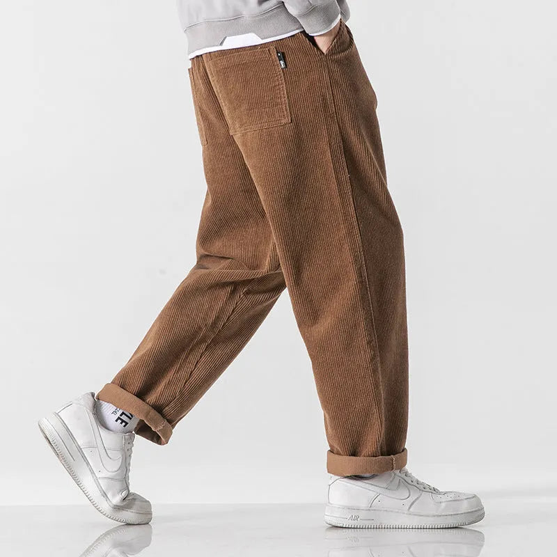 Men's loose straight corduroy sports trousers in army green colour on a hanger