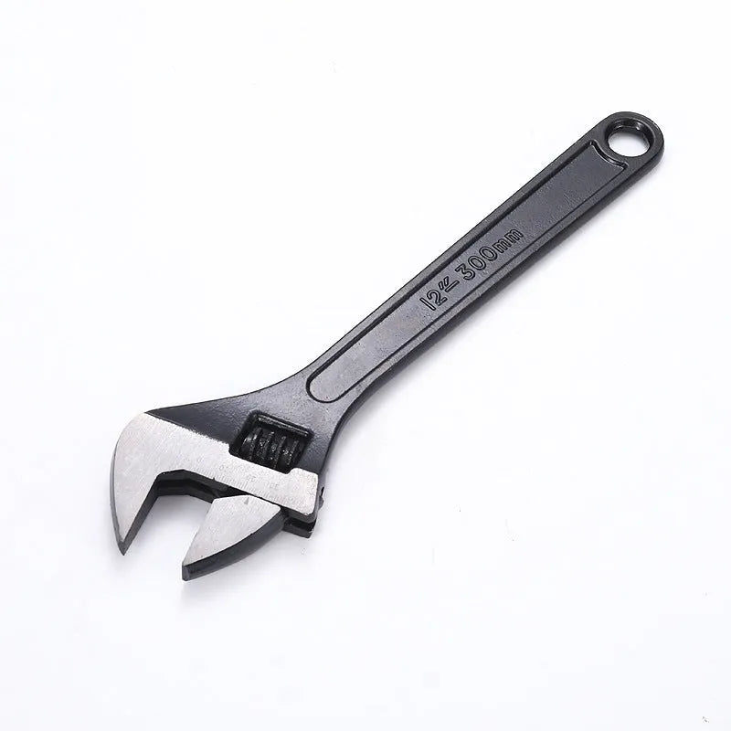 High carbon steel adjustable open-end wrench with black finish on a workbench.