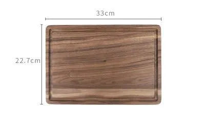 Solid black walnut wood chopping board with a deep perimeter groove and a side handle, shown as a serving tray.