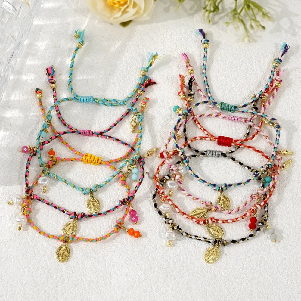 Close-up of a woman's hand-woven colourful braided rope bracelet in ethnic style, showing textured weave detail.