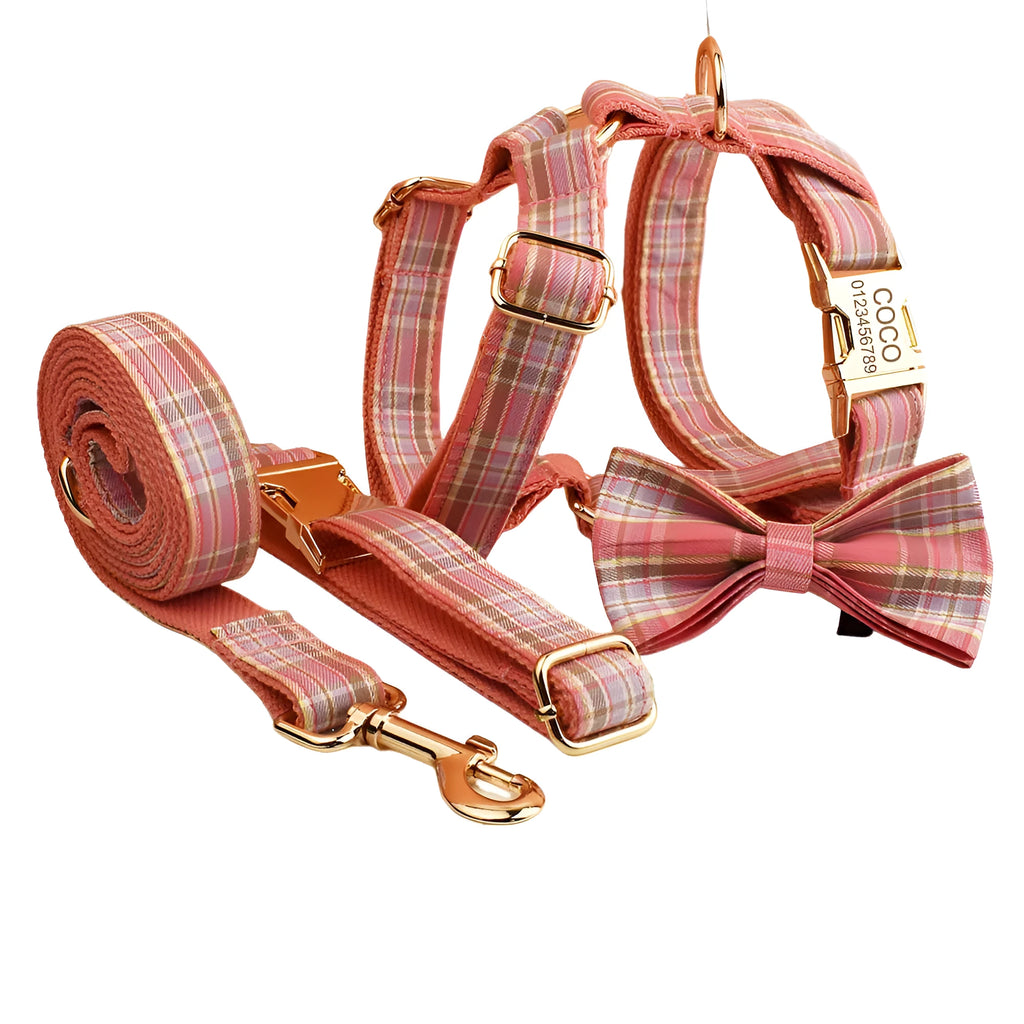 Plaid cloth fabric dog collar, vest, bow tie, and leash set laid out flat.