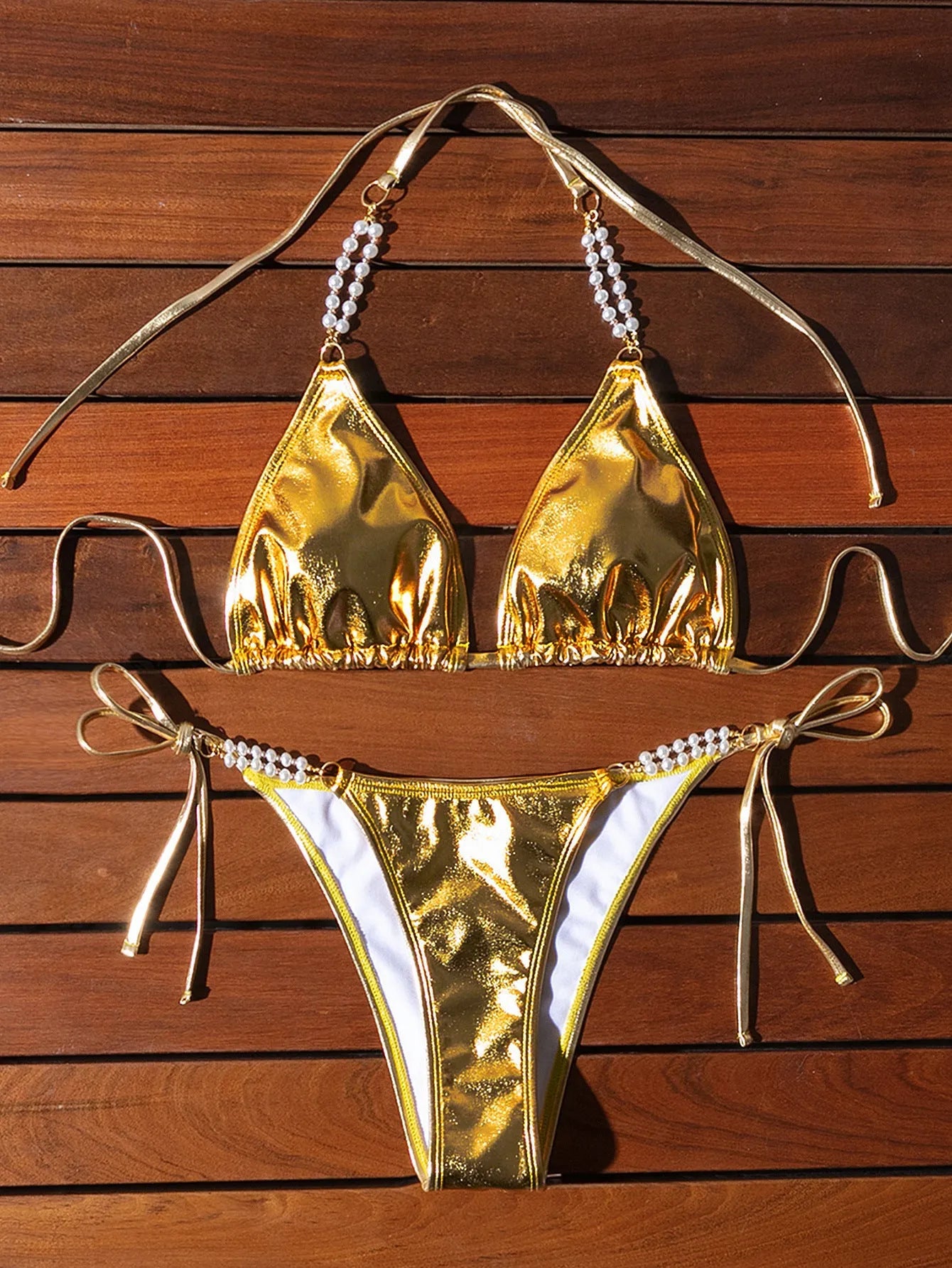 Gold halter bikini with lace-up front and pearl chain detail, brief cut swimsuit