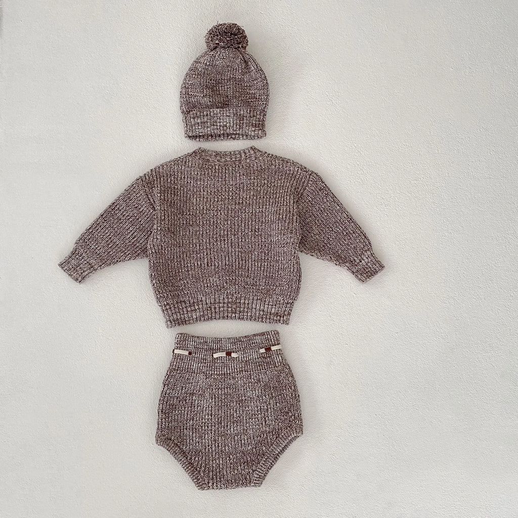 Dark brown knitted 3-piece set for infant girl with pullover blouse, pants, and fur ball hat