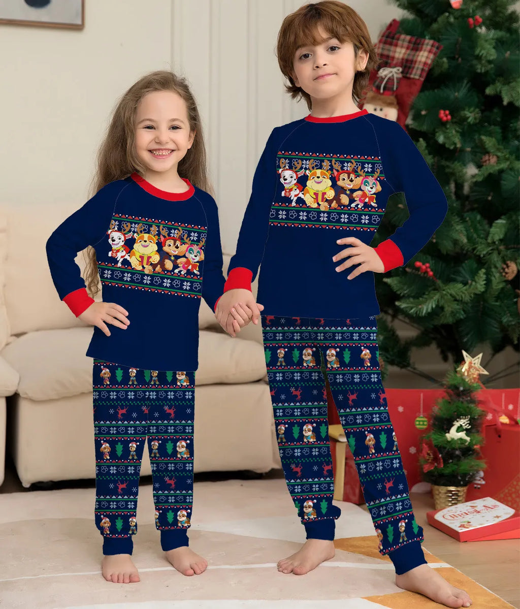 Family wearing matching red plaid Christmas pyjamas with deer print, including adults, children, and a dog.