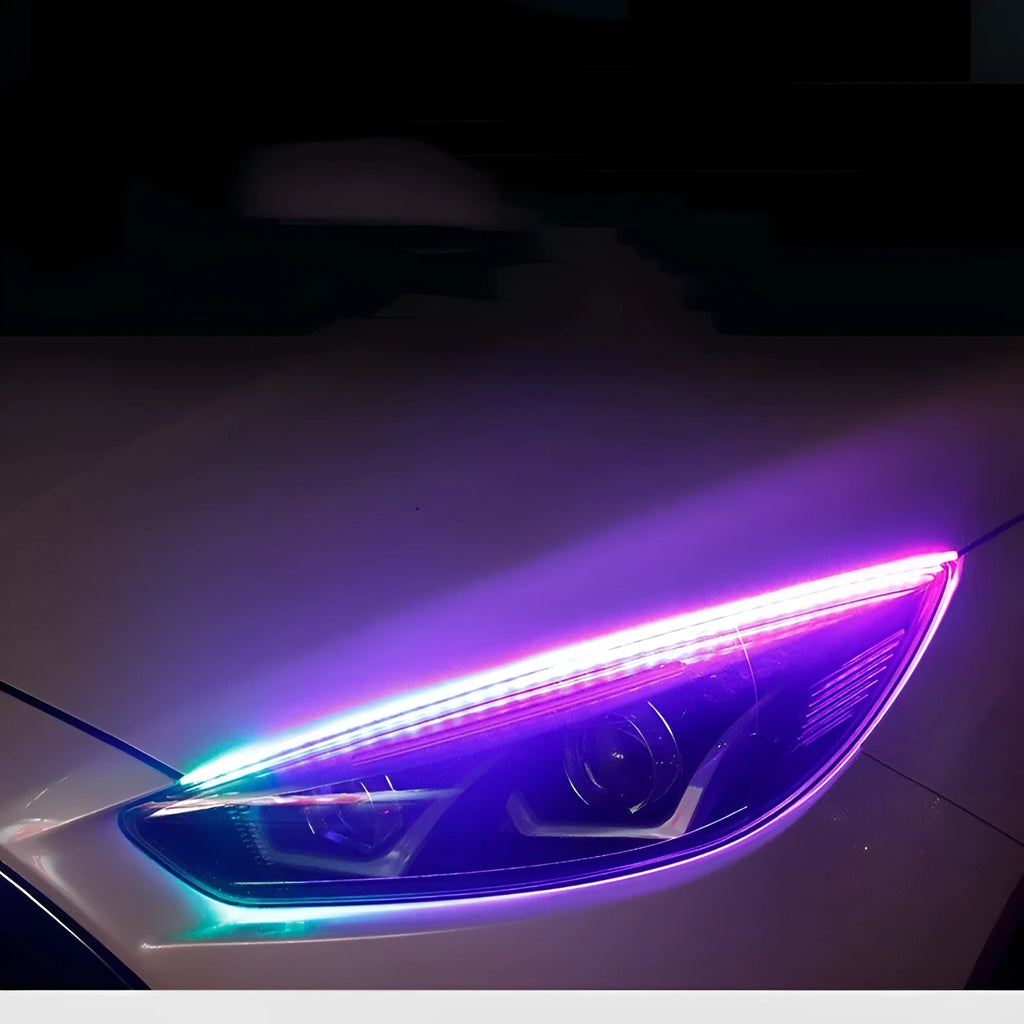 Close-up of a multi-colour RGB LED daytime running light strip with a remote control on a car bumper.