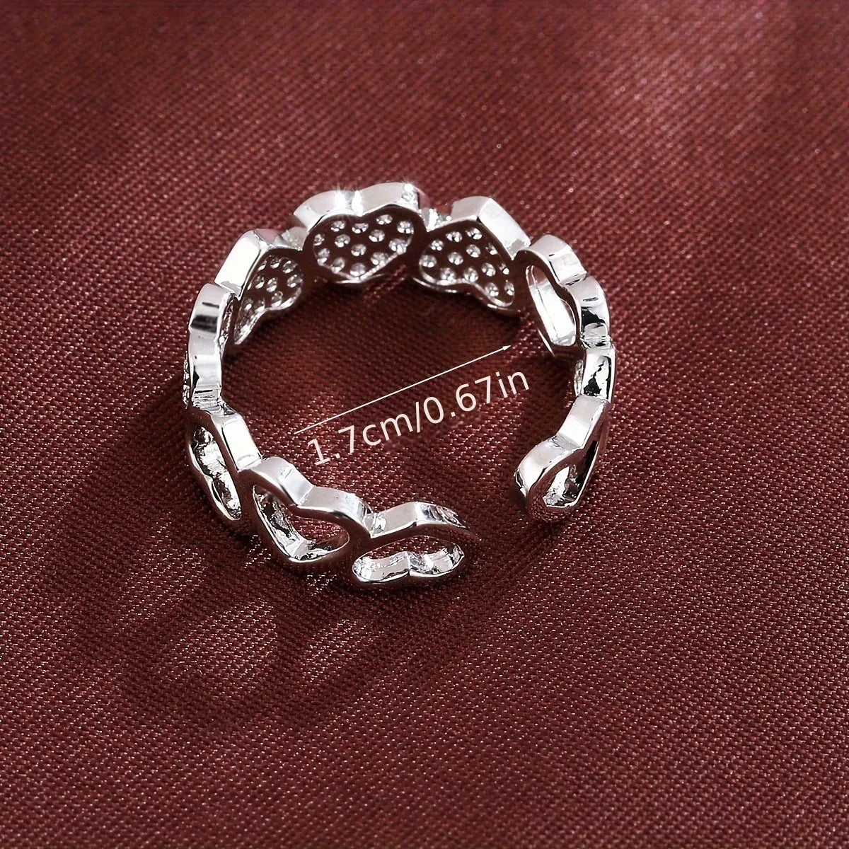 Gold and silver adjustable heart-shaped couples ring on a small finger.