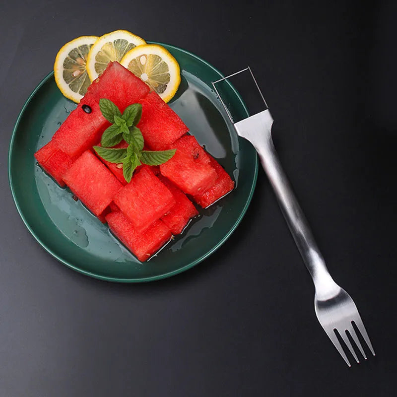 Silver stainless steel watermelon slicer and serving fork on a kitchen counter
