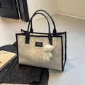 Women's black and white rhombus pattern canvas tote bag with shoulder strap showing horizontal square shape