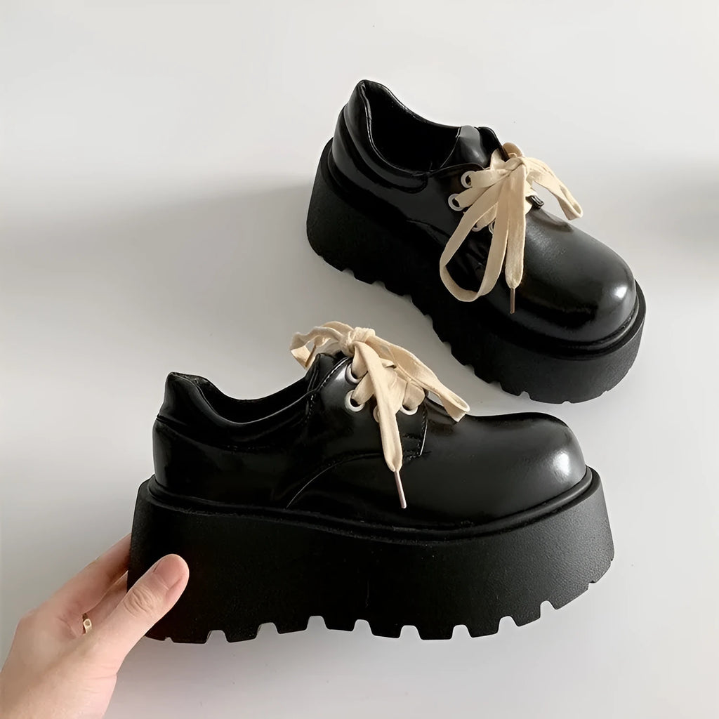 Matte black women's retro lace-up shoes with a thick sole and a muffin heel.