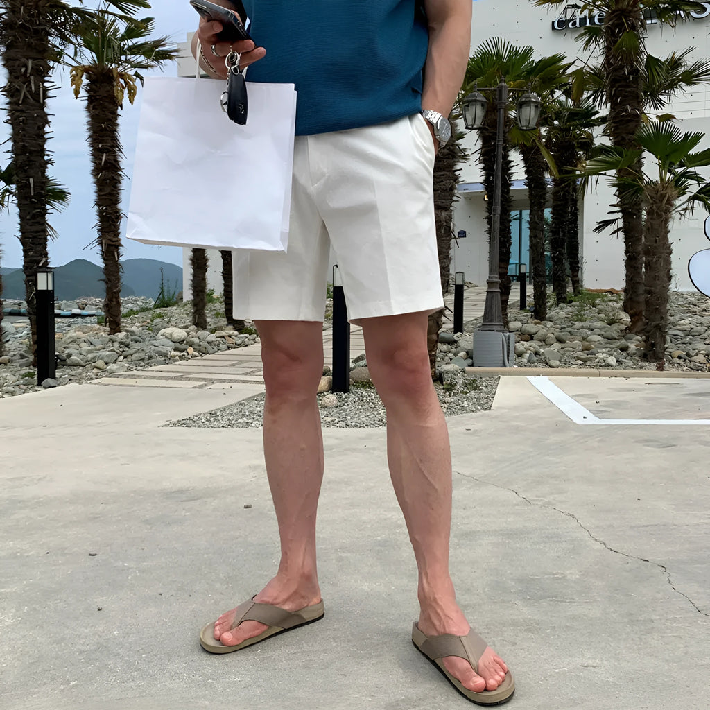 Man wearing loose straight-cut casual polyester shorts in a solid colour.