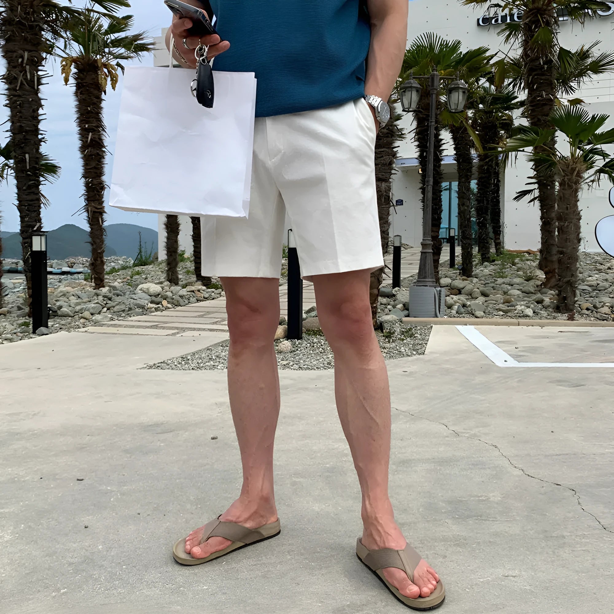 Man wearing loose straight-cut casual polyester shorts in a solid colour.