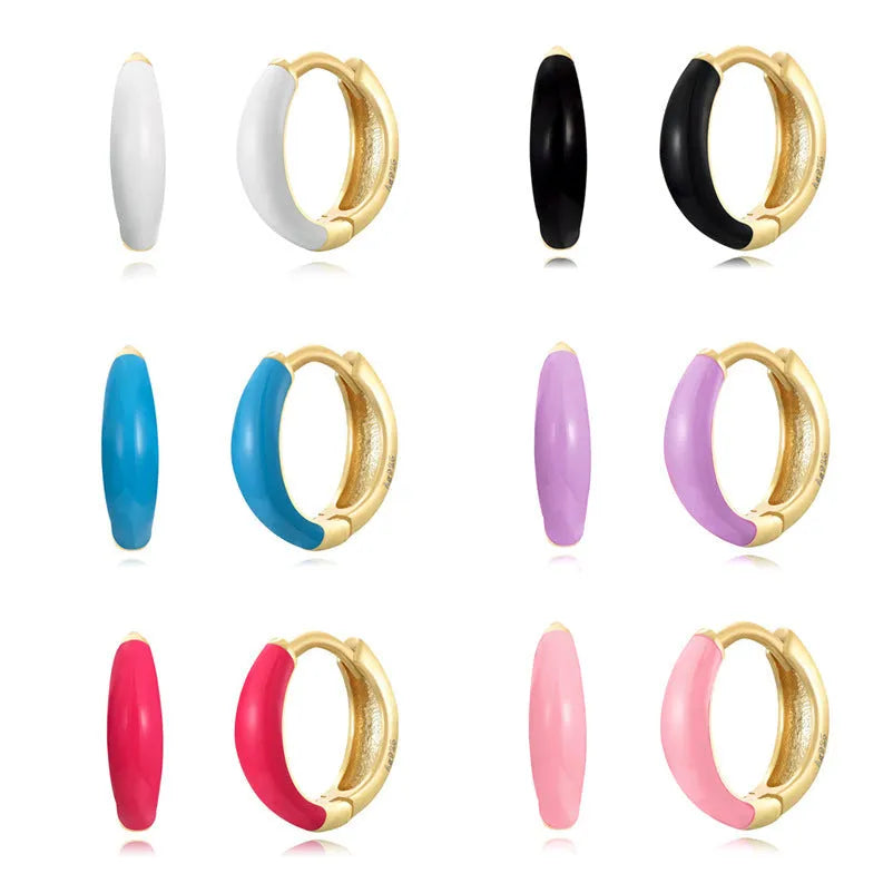 Pair of curved oval epoxy earrings in geometric ring design on a U-shaped hook.