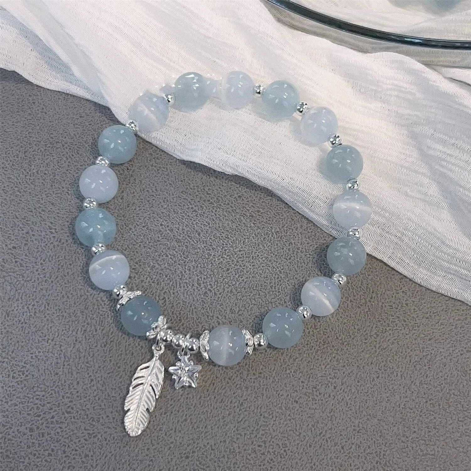 Glass crystal bracelet with coloured glaze in blue moonlight colour showing text modelling and eight-point star detail