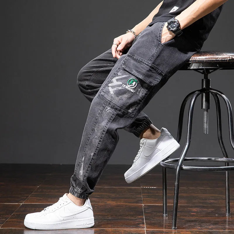 Man wearing loose straight leg cargo jeans in blue, showing mid waist and zipper fly detail.