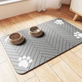Blue diatom ooze pet feeding mat on a kitchen floor next to a water bowl.