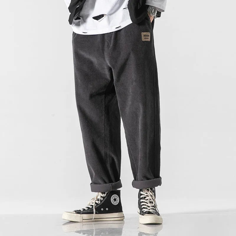 Men's loose straight corduroy sports trousers in army green colour on a hanger