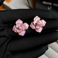 Close-up of gold plated purple oil-spot glaze flower stud earrings on a copper base.