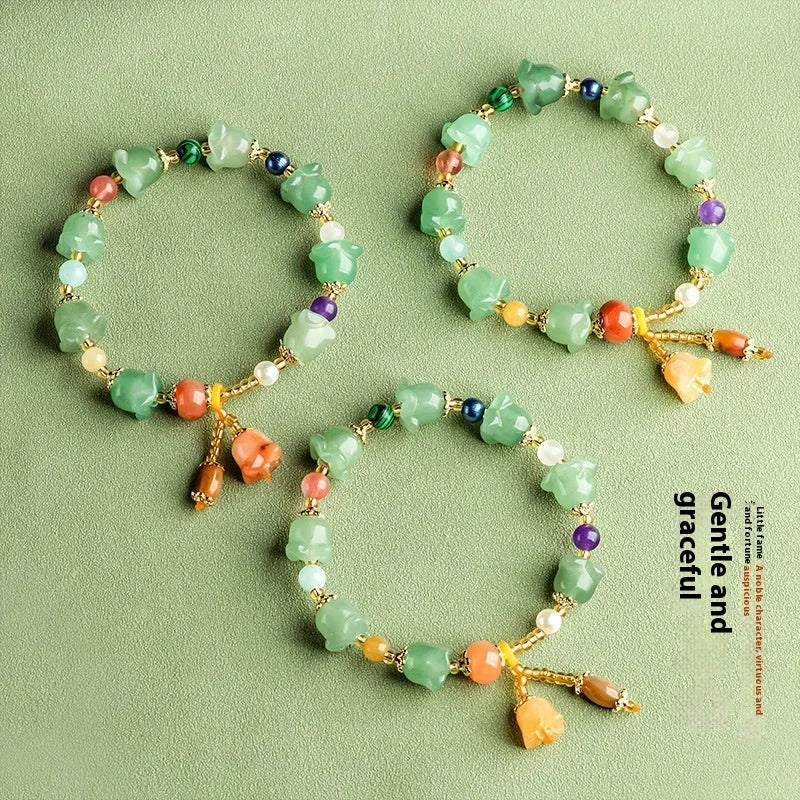 Natural Xinjiang Jinsi Jade aventurine orchid bracelet with carved orchid beads on a wrist.