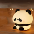 Cartoon panda silicone night light for kids with clap control on a bedside table
