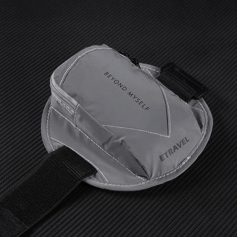 Black reflective running arm band wrapped around an arm, showing its strap and phone compartment.