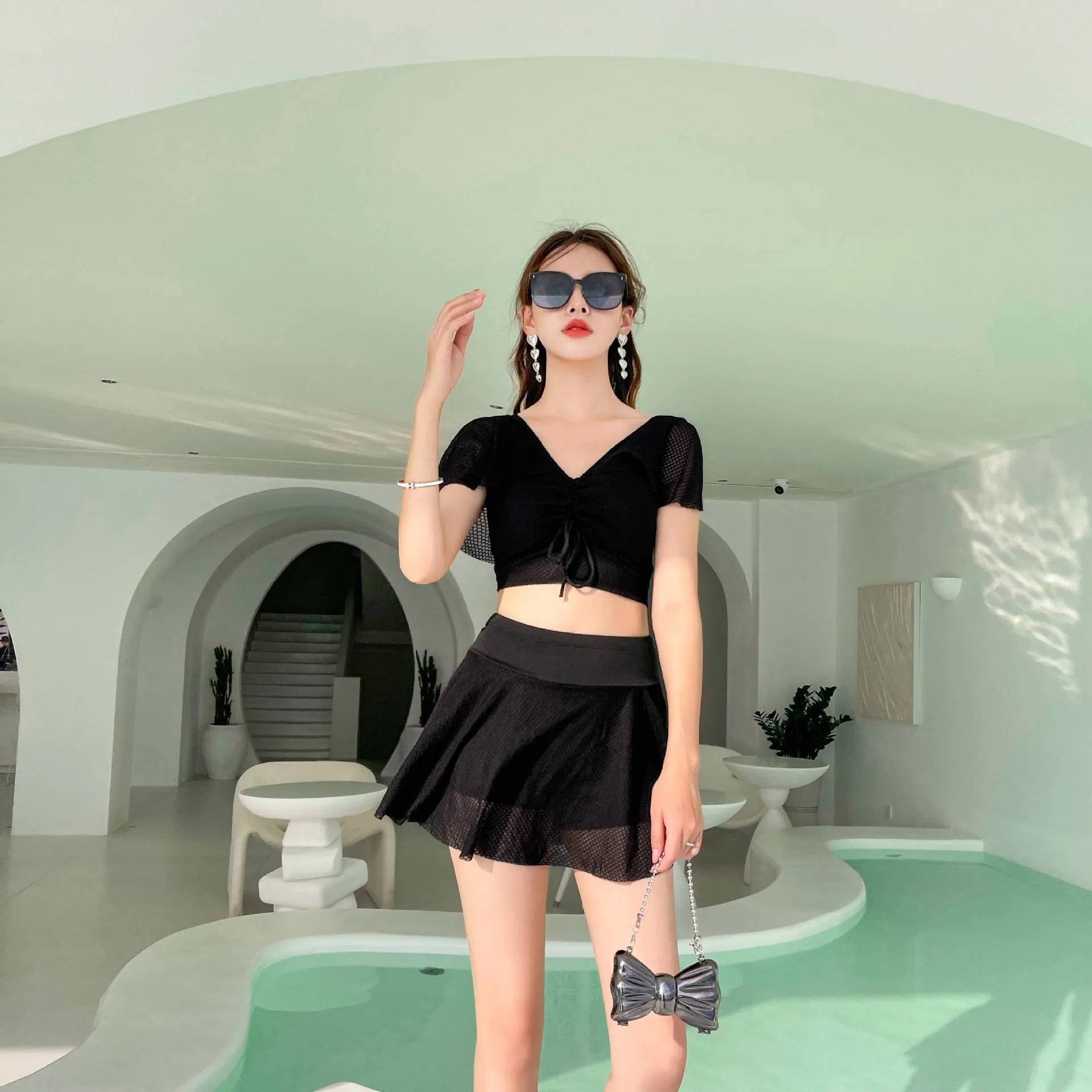 Women's solid colour two-piece swimsuit set with a top and split skirt.