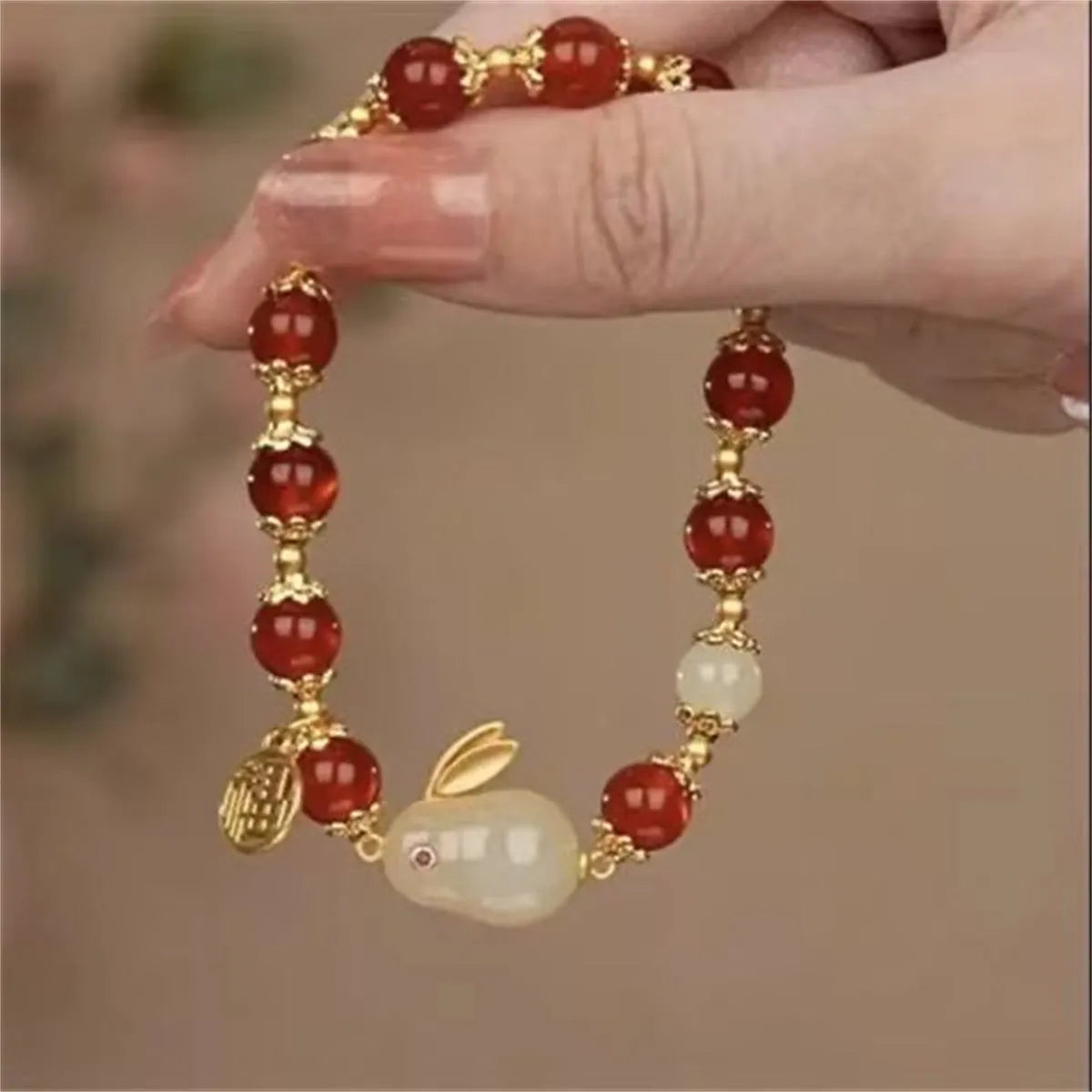 Simple women's bracelet with a peace buckle charm, coloured glass beads, and a small rabbit charm.