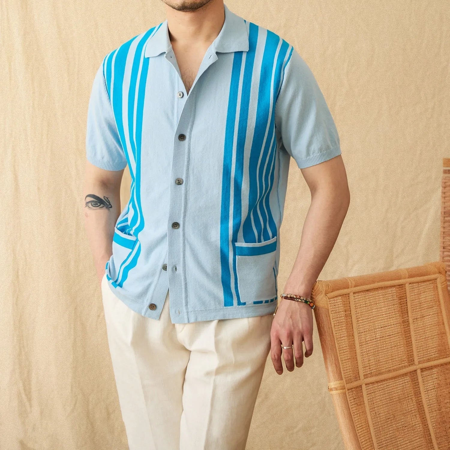 A thin, short-sleeved striped cardigan polo shirt with a lapel collar in a light blue colour.