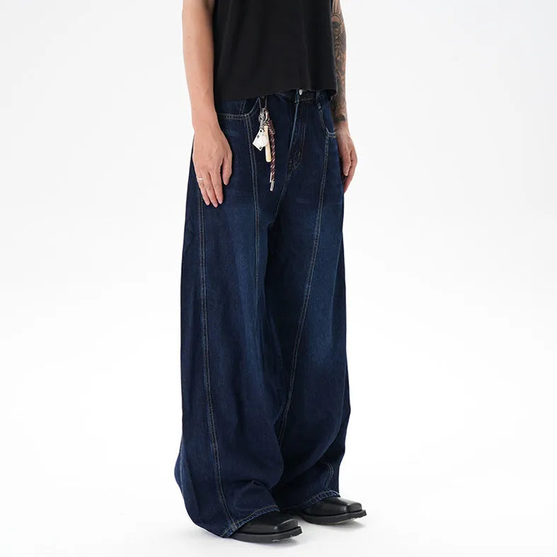 Dark blue distressed wide leg jeans with a machete cut design on a denim fabric.