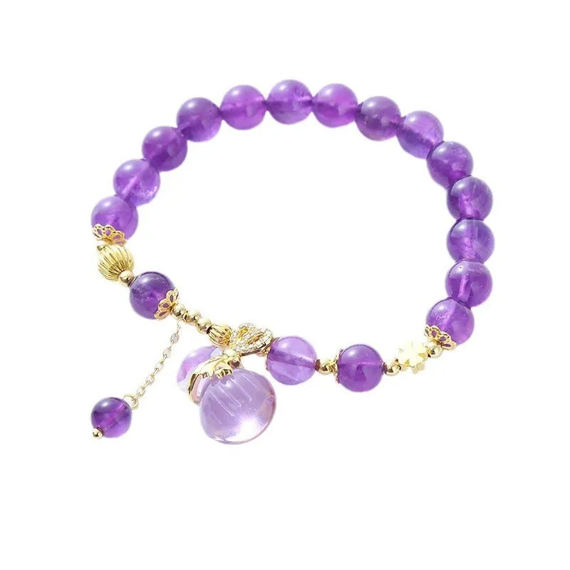 Purple amethyst bracelet with ethnic-style money bag pendant and geometric shapes on wrist