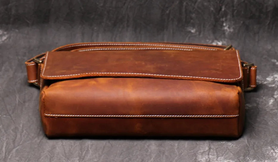 Men's vintage brown cowhide shoulder bag showing medium size and cross-body strap