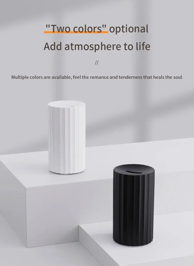 Black and white essential oil diffuser and humidifier with a simulated LED flame effect on a table.