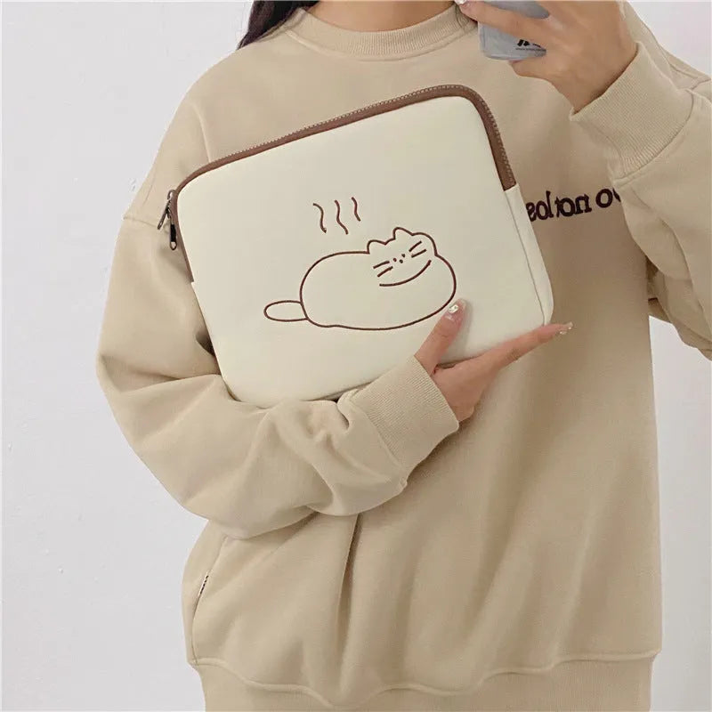 Embroidered cat design on a nylon tablet protective sleeve with a zipper.