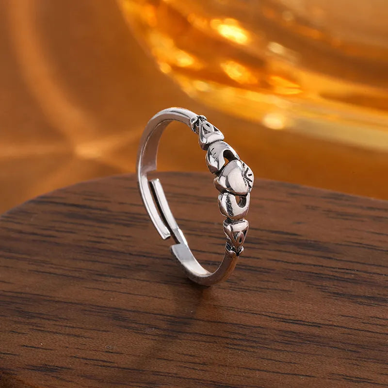 Retro silver heart open ring on finger showing adjustable copper construction and heart silhouette
