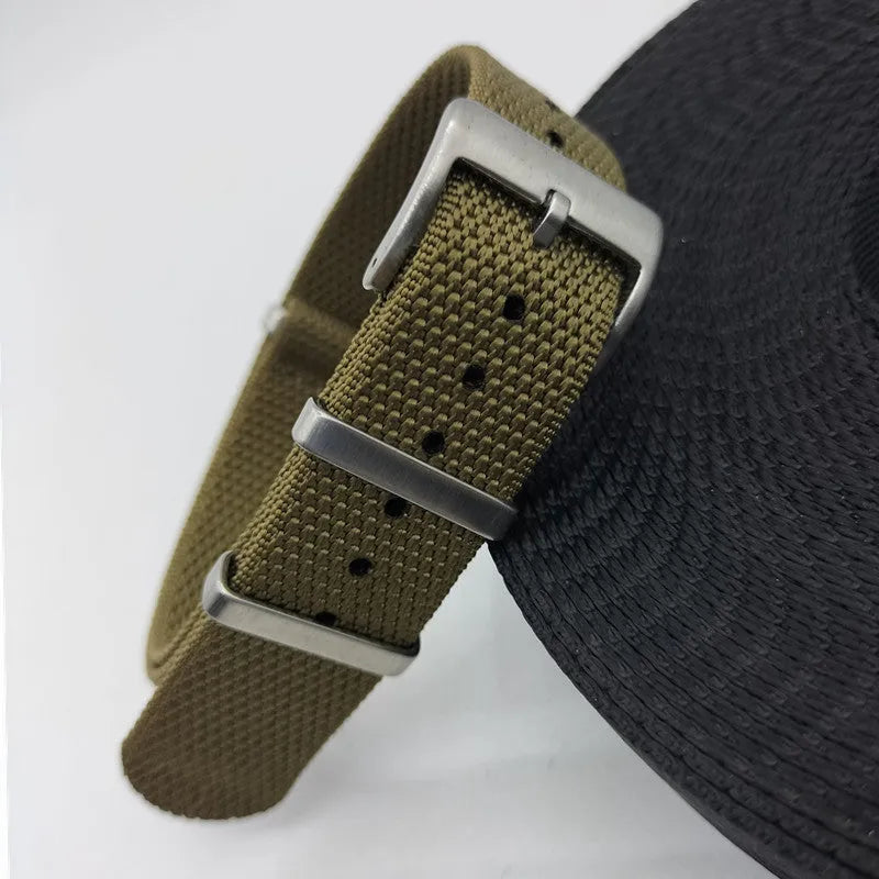 Nylon textile watch strap in army green colour with metal buckle, shown alongside black and blue options.