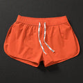 Men's loose-fitting beach shorts in orange, fluorescent green, and black colours on a size chart background