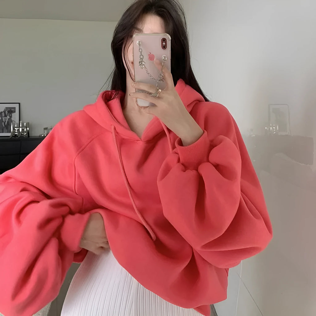 Women's loose watermelon red mulberry silk hooded pullover sweater on a hanger.