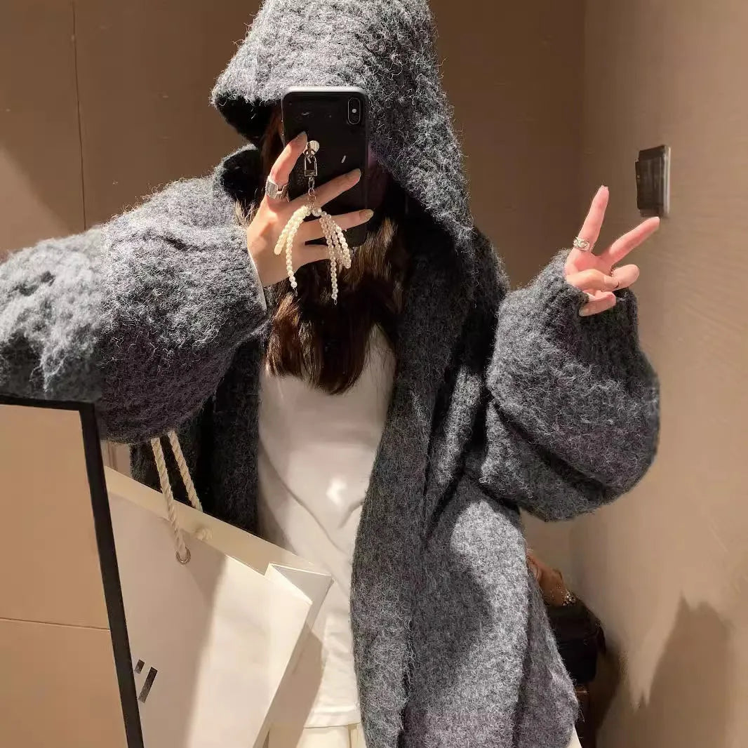 A woman wearing a brown retro-style hooded cardigan with thick knit fabric.