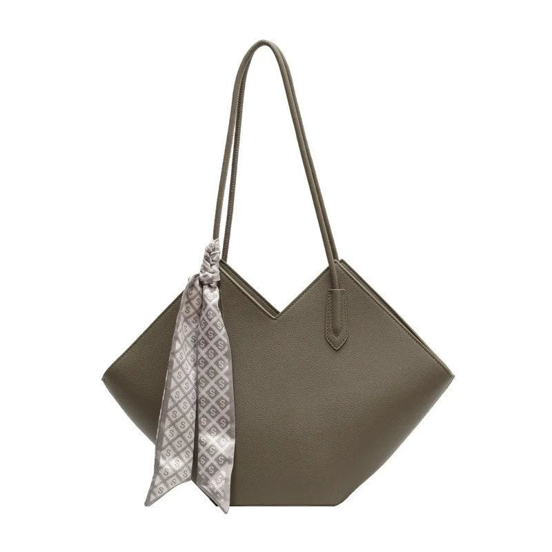 Women's large beige PU shoulder bag with square shape and long strap on a plain background.