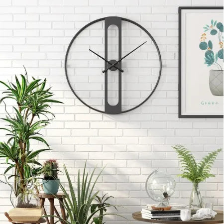 Round metal wall clock with 50 cm diameter in black or gold finish on a wall