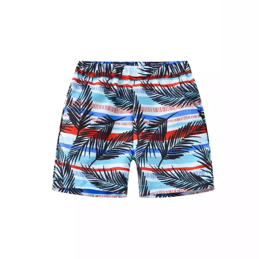 Colourful printed beach shorts on a hanger showing coconut tree and dinosaur designs.
