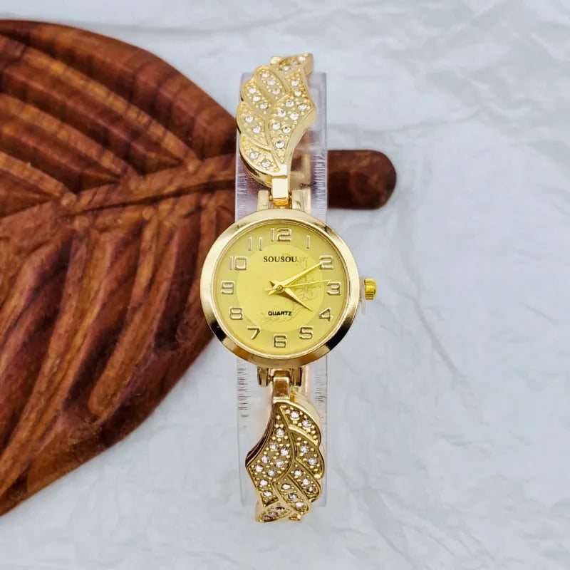 Stainless steel women's wristwatch with a round dial and vachette clasp, showing a gold-coloured surface.