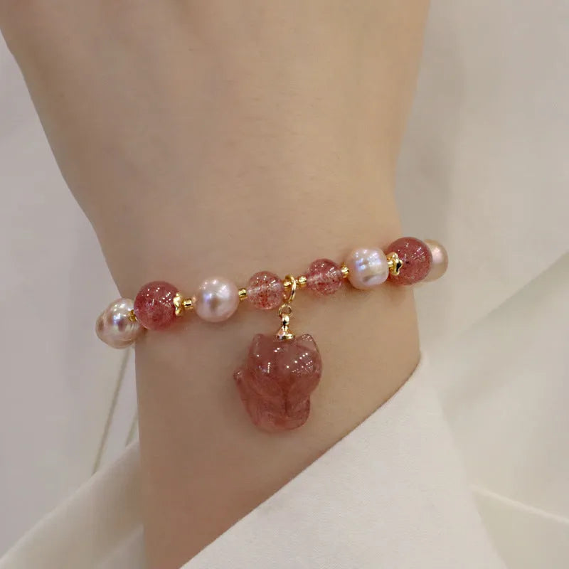 Women's light pink freshwater pearl bracelet with strawberry quartz and fox charm detailing